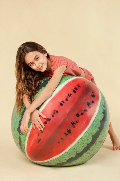 Chica de tiro completo posando con bola de sandía