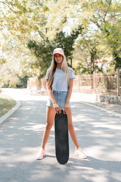 Chica de tiro completo posando con patineta