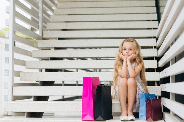 Chica de tiro completo sentado en las escaleras