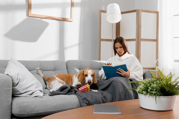 Chica de tiro completo en el sofá con el perro