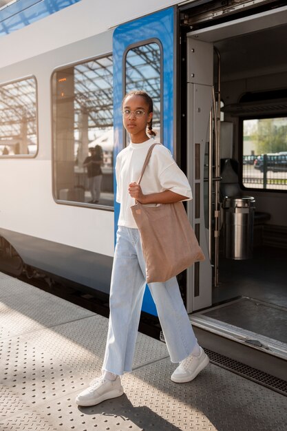 Chica de tiro completo viajando en tren.