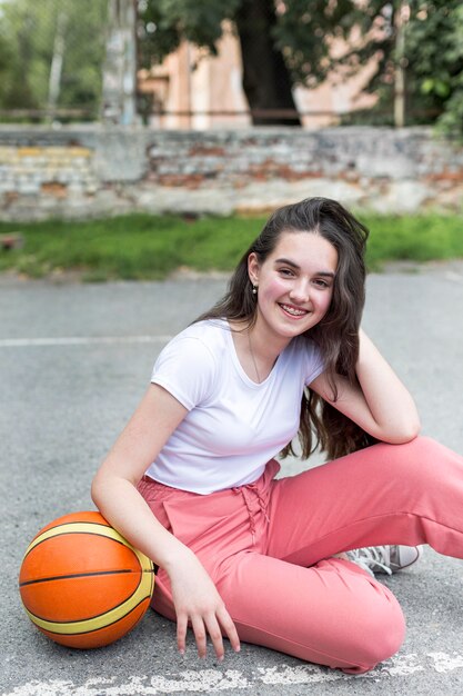 Chica de tiro largo sosteniendo una pelota de baloncesto