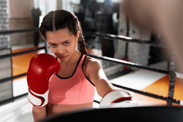 Foto gratuita chica de tiro medio aprendiendo boxeo