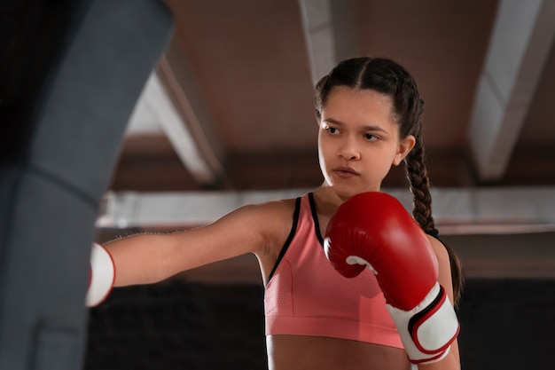 Chica de tiro medio aprendiendo boxeo