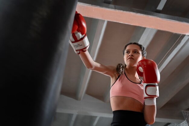 Chica de tiro medio aprendiendo boxeo