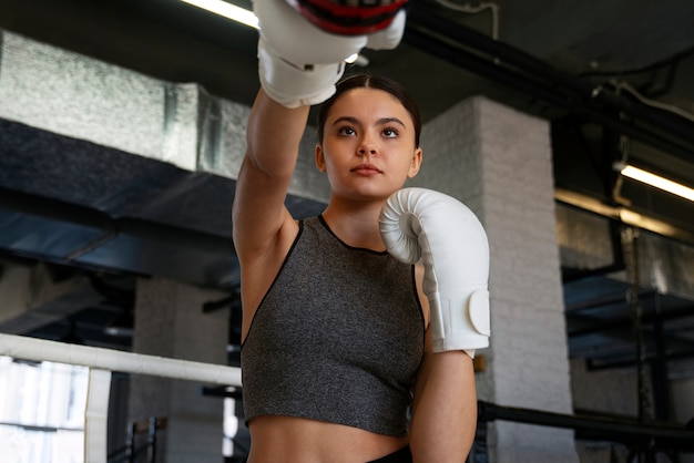 Chica de tiro medio aprendiendo boxeo