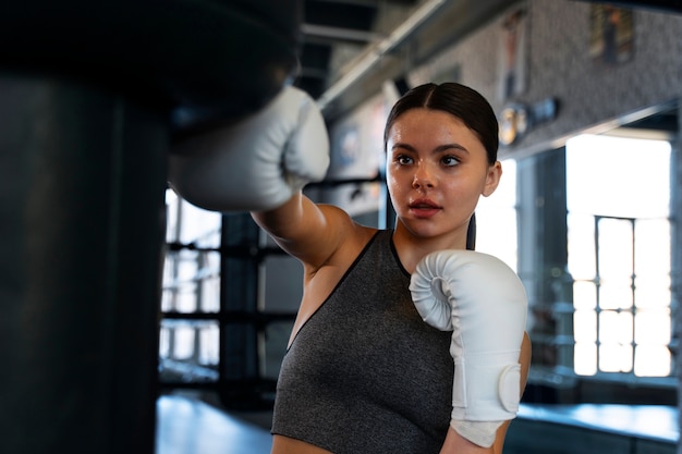 Foto gratuita chica de tiro medio aprendiendo boxeo