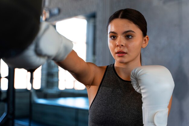 Chica de tiro medio aprendiendo boxeo