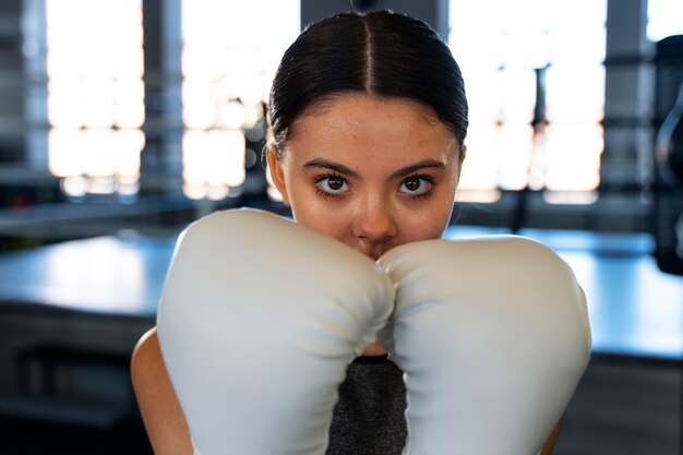 Chica de tiro medio aprendiendo boxeo