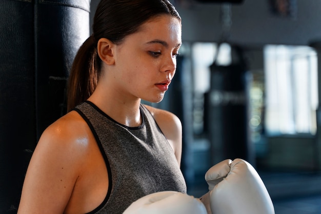 Chica de tiro medio aprendiendo boxeo