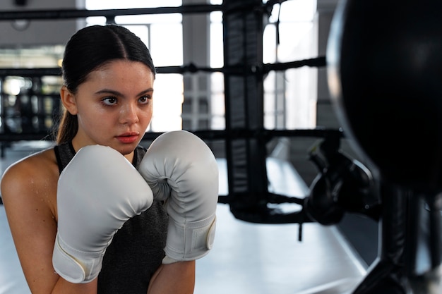 Chica de tiro medio aprendiendo boxeo