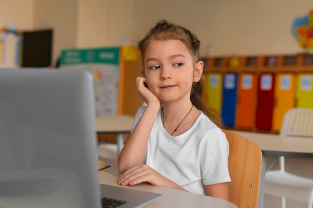 Chica de tiro medio aprendiendo en la escuela.