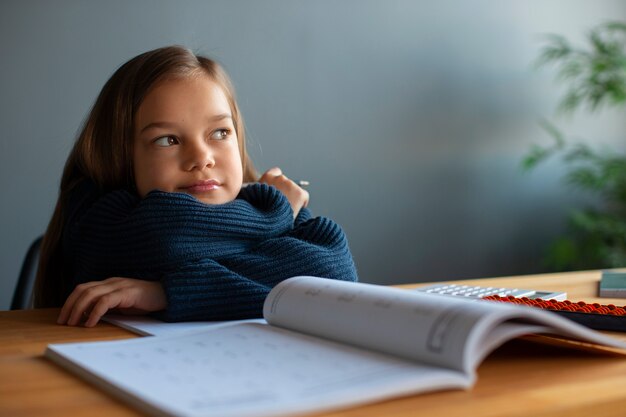 Chica de tiro medio aprendiendo matemáticas en la escuela.