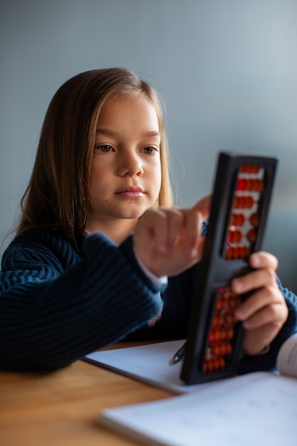 Chica de tiro medio aprendiendo matemáticas en la escuela.