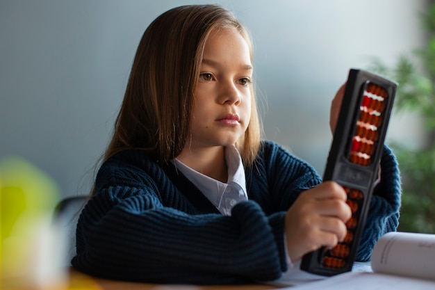 Chica de tiro medio aprendiendo matemáticas en la escuela.