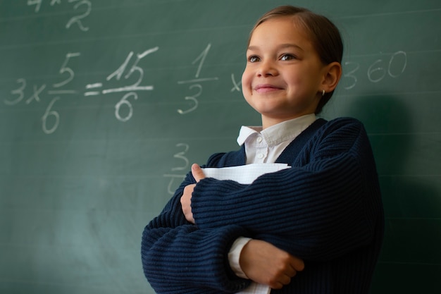 Foto gratuita chica de tiro medio aprendiendo matemáticas en la escuela.