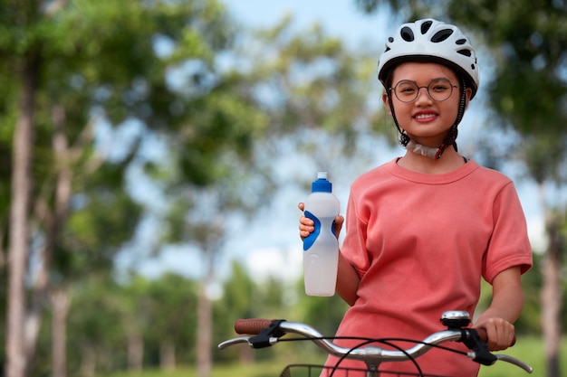 Foto gratuita chica de tiro medio en bicicleta al aire libre