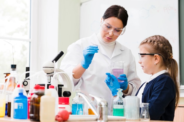 Chica de tiro medio y científico en laboratorio