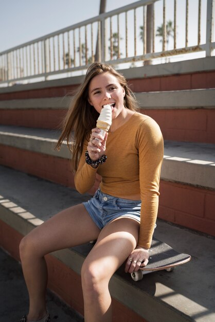 Chica de tiro medio comiendo helado