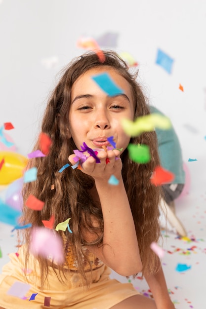 Chica de tiro medio divirtiéndose con confeti