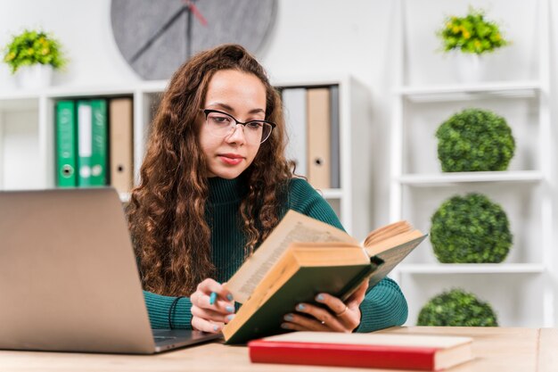 Chica de tiro medio estudiando con diccionario