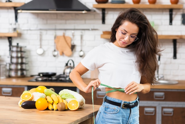 Foto gratuita chica de tiro medio con gafas con cinta métrica