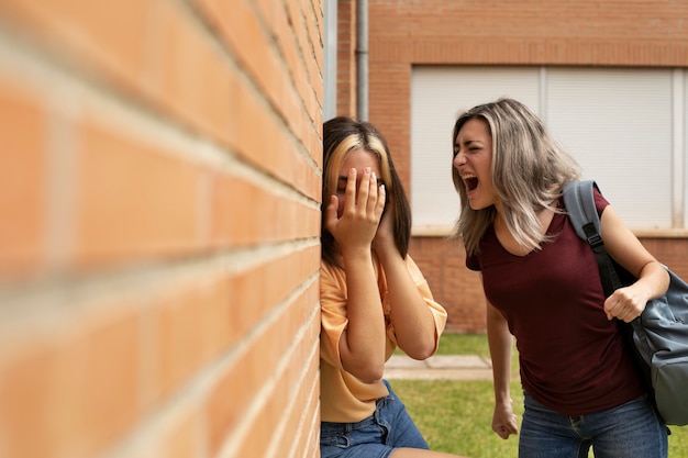 Chica de tiro medio gritando a colega