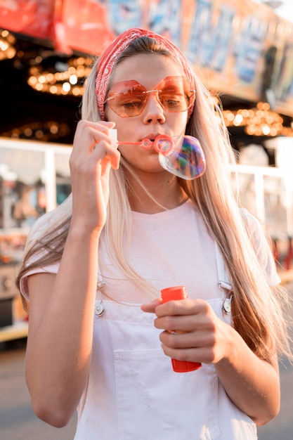 Foto gratuita chica de tiro medio haciendo globos de jabón