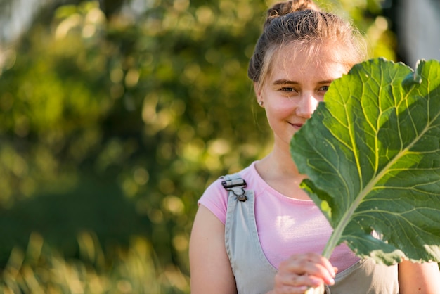 Foto gratuita chica de tiro medio con hoja de lechuga