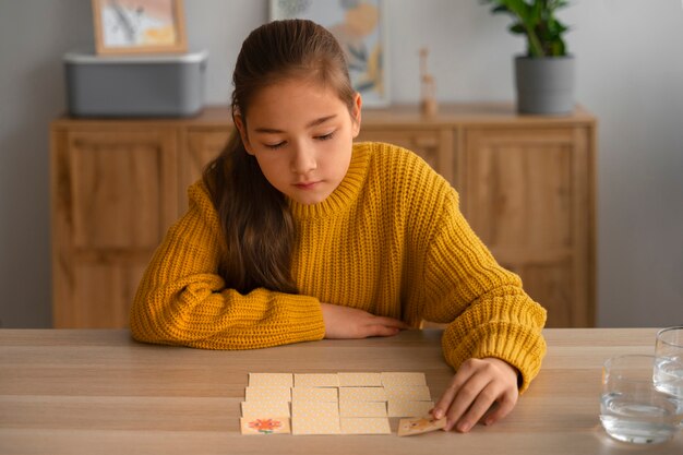 Chica de tiro medio jugando juego de memoria