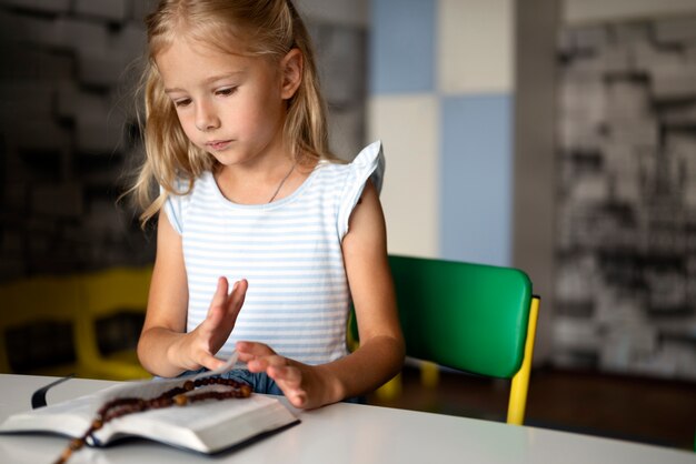 Chica de tiro medio leyendo la biblia