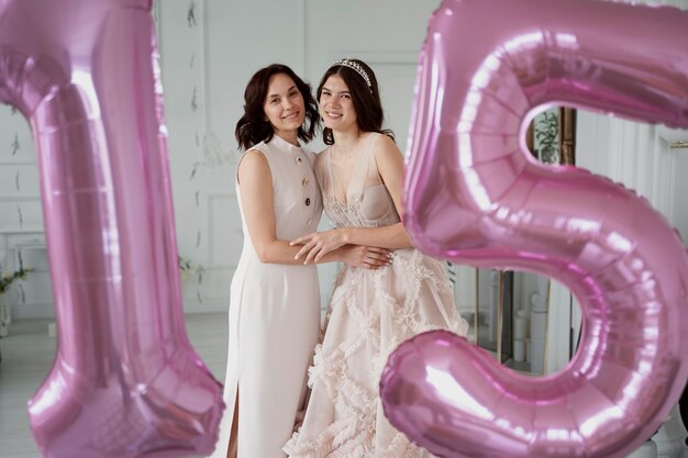 Chica de tiro medio y madre posando juntas