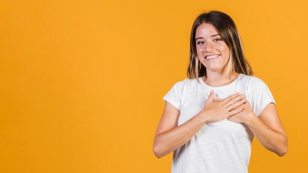 Chica de tiro medio con las manos en el pecho.