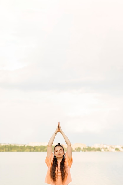 Foto gratuita chica de tiro medio meditando al aire libre