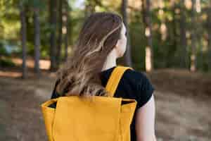 Foto gratuita chica de tiro medio con mochila en el bosque