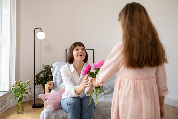 Chica de tiro medio ofreciendo flores