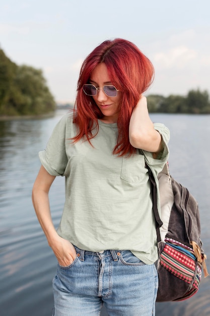 Foto gratuita chica de tiro medio posando frente al lago