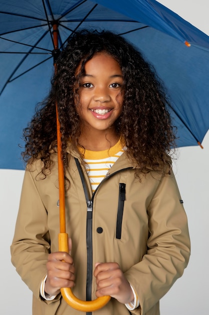 Chica de tiro medio posando con paraguas