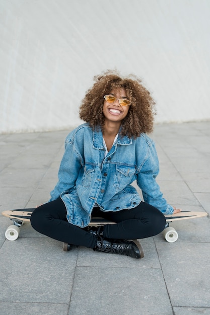 Foto gratuita chica de tiro medio posando en patineta