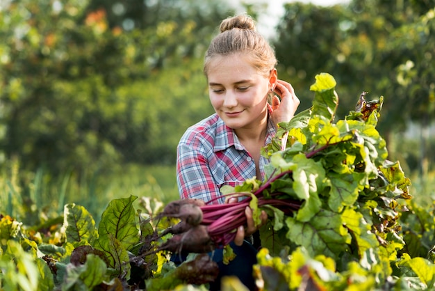 Chica de tiro medio recogiendo verduras