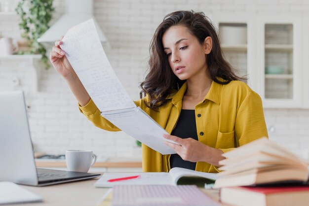 Chica de tiro medio revisando sus notas