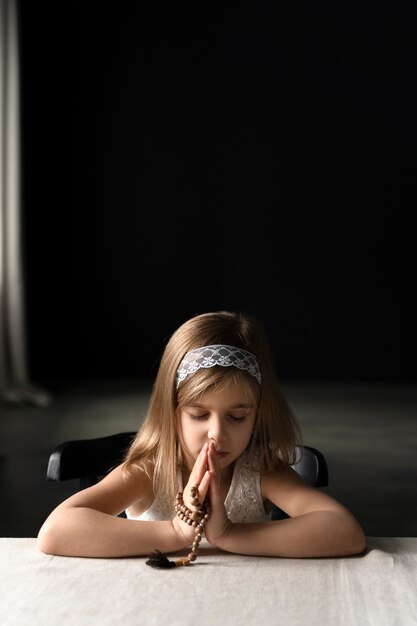 Foto gratuita chica de tiro medio rezando con crucifijo.