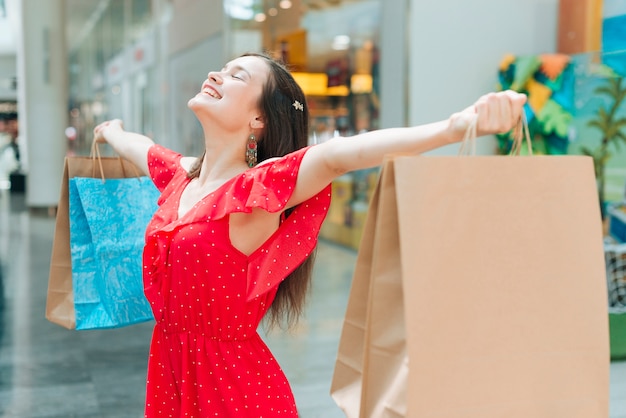 Foto gratuita chica de tiro medio sintiéndose alegre en el centro comercial.