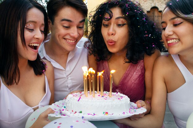 Chica de tiro medio soplando velas