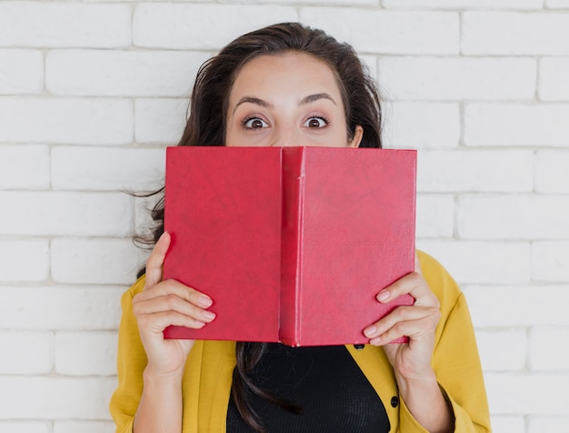 Foto gratuita chica de tiro medio sosteniendo libro con tapa roja