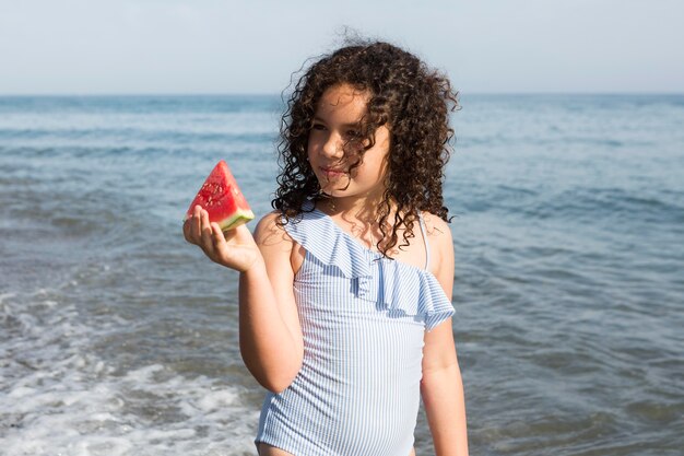 Chica de tiro medio sosteniendo sandía