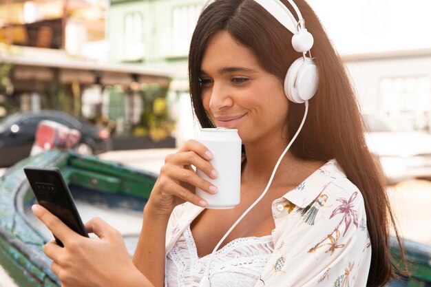 Chica de tiro medio con teléfono y auriculares