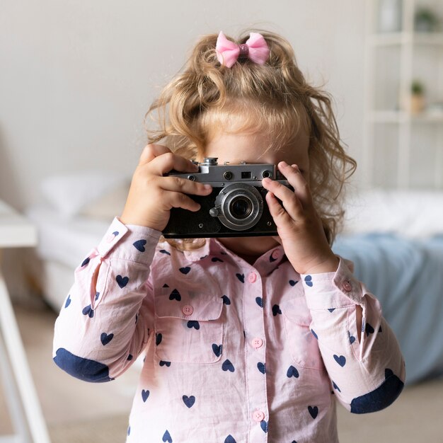 Chica de tiro medio tomando fotos con la cámara