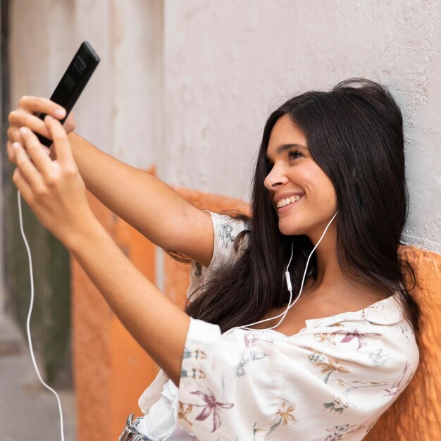 Chica de tiro medio tomando selfie