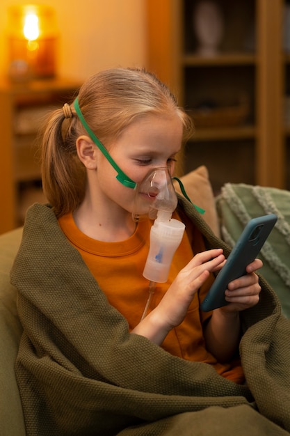 Foto gratuita chica de tiro medio usando nebulizador